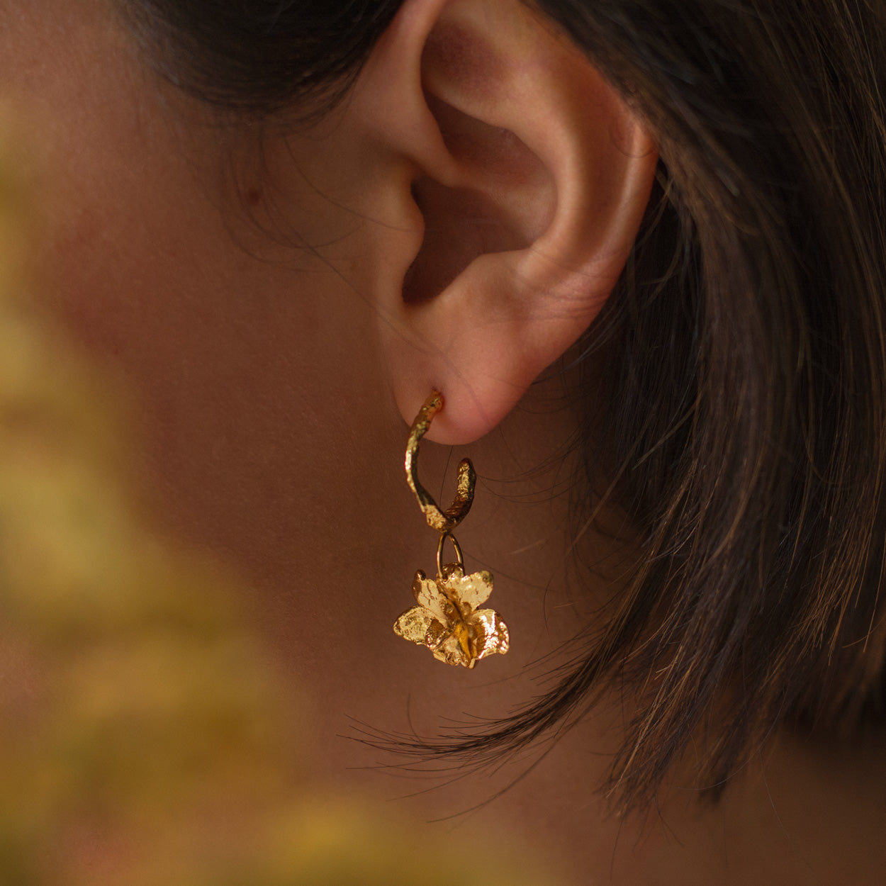 Model wearing Maxilaria Orchid Hoop Earrings, showcasing the elegance and nature-inspired design.