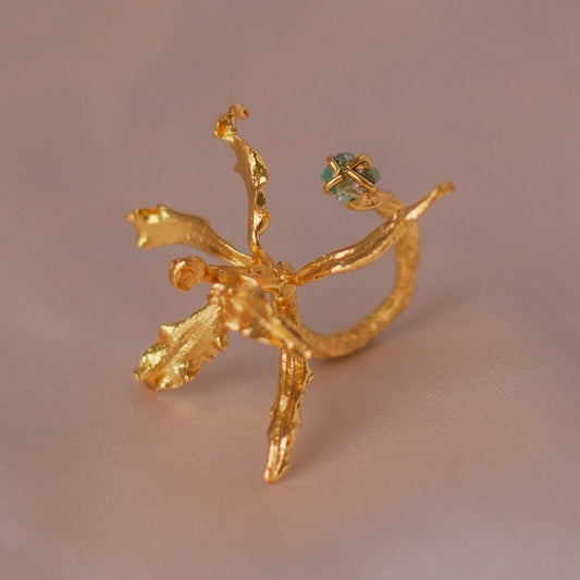 Cyrtochilum Revolutum Orchid Ring with Emerald in 24k gold, showcasing natural elegance.