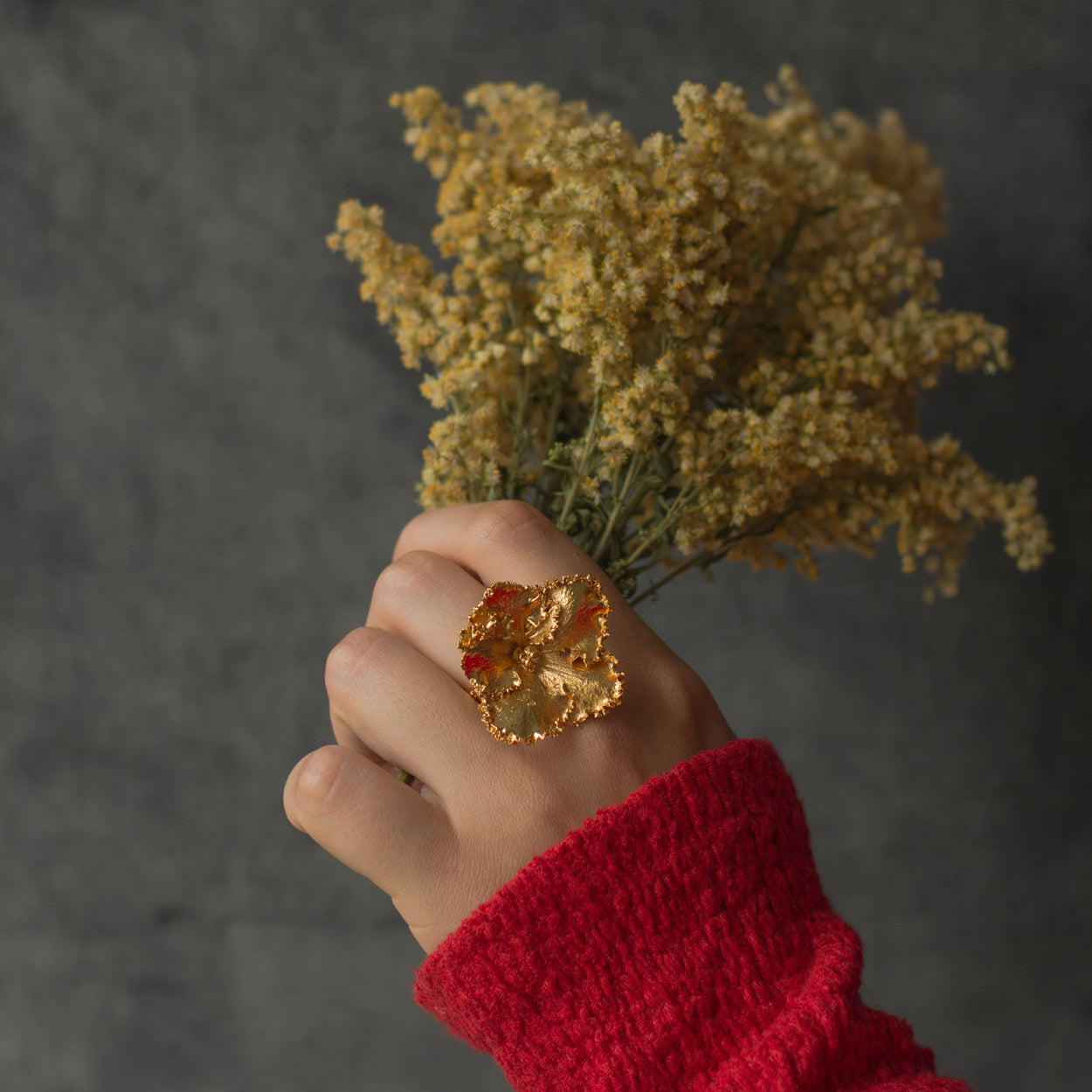 Hand wearing the Ornamental Flower Ring crafted from a real flower, highlighting its natural, elegant details.