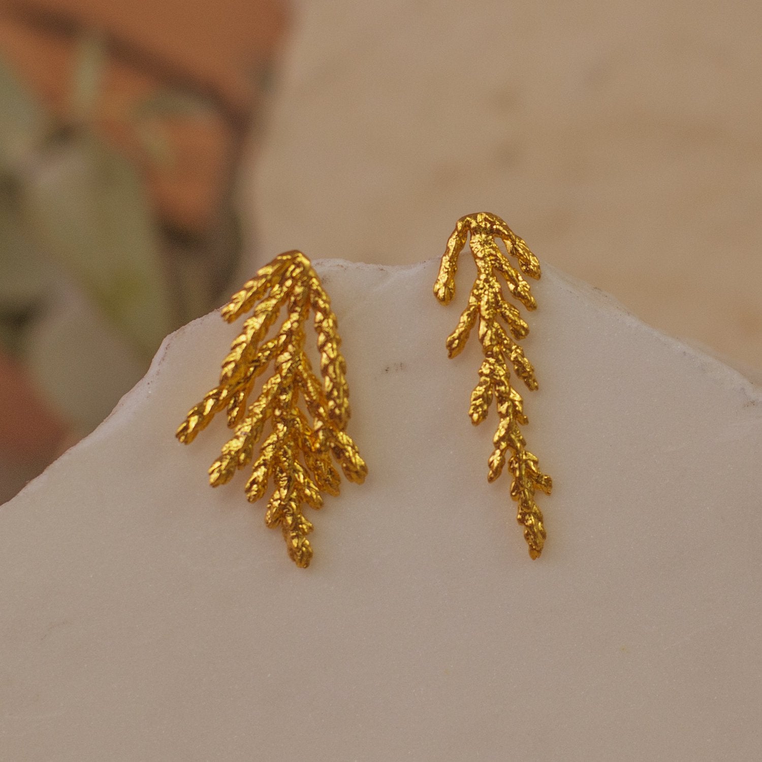 Close-up of Pine Leaf Stud Earrings, highlighting the preserved leaf texture and 24k gold plating.