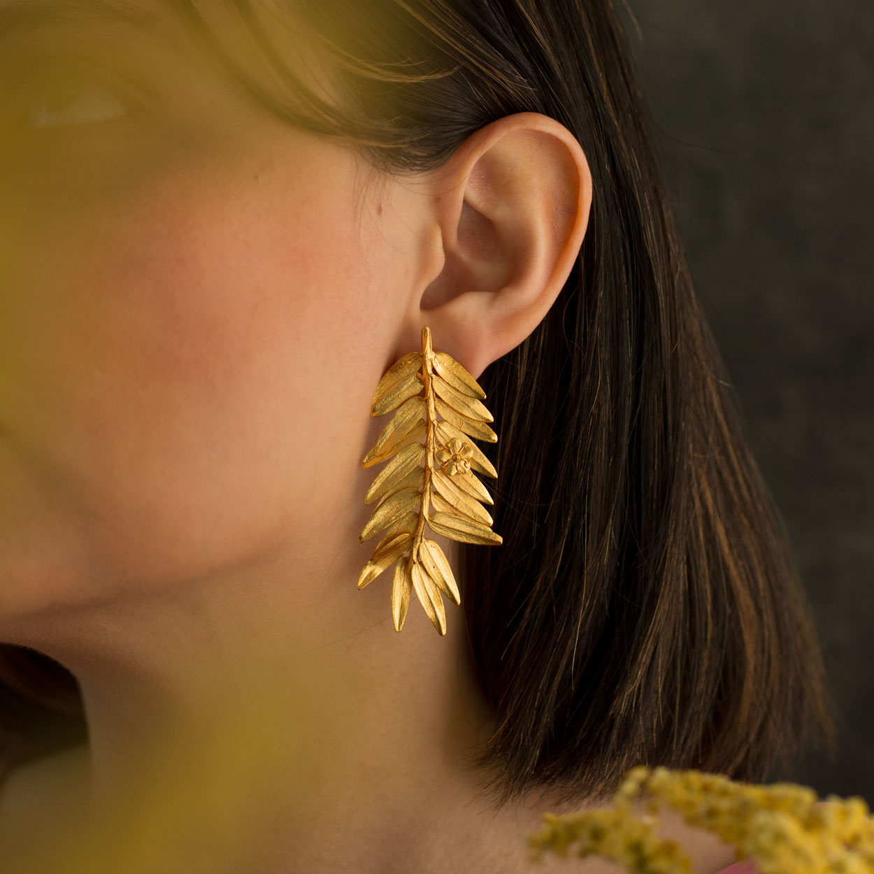 Model wearing Romeron Pine & Elderflower Earrings, showcasing the blend of natural elegance and luxury.