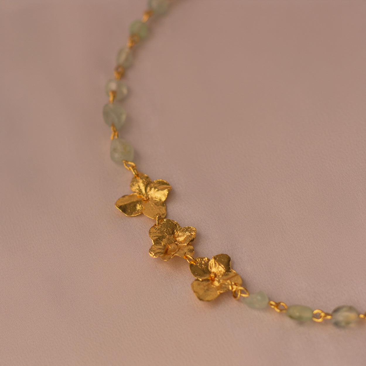 Collar Choker Cuarzos Tres Hortensia en bronce bañado en oro de 24k con cuarzos de ágata verde natural, destacando la belleza y singularidad de las flores inmortalizadas.
