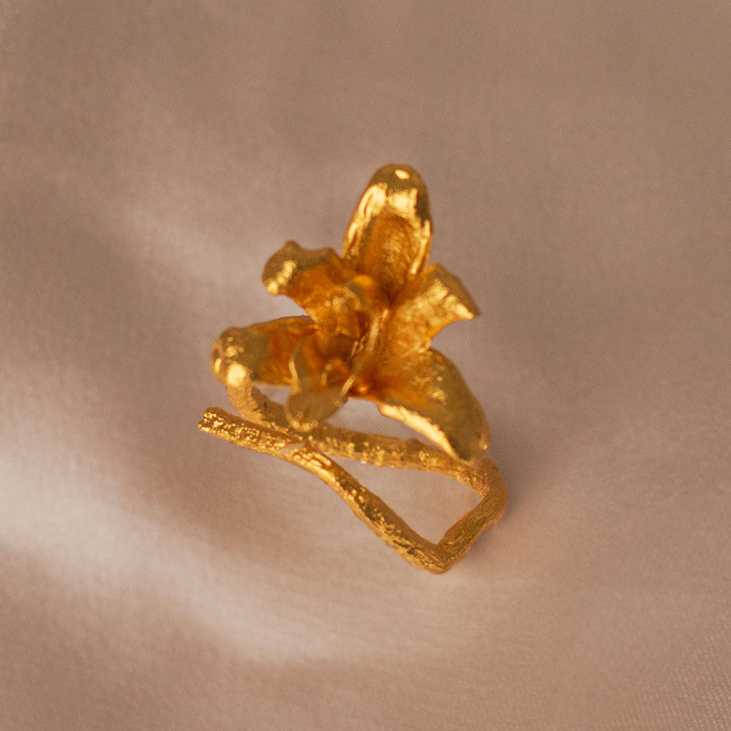 Anillo Orquídea Maxilaria en bronce bañado en oro de 24k, mostrando la forma delicada y única de una flor natural de orquídea
