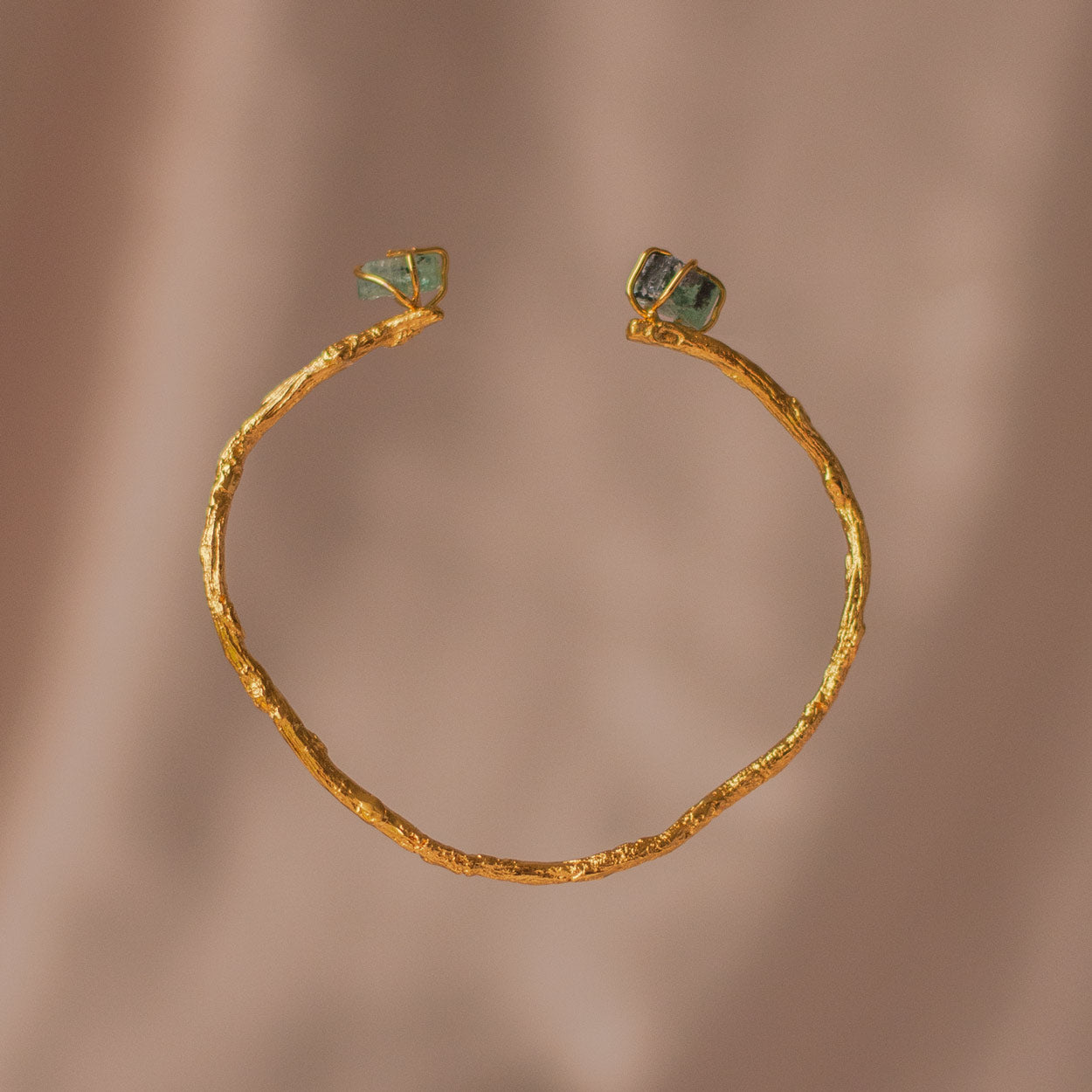 A unique Emerald Palm Twig Bracelet, showing the intricate twigs and emeralds in a luxurious 24k gold finish