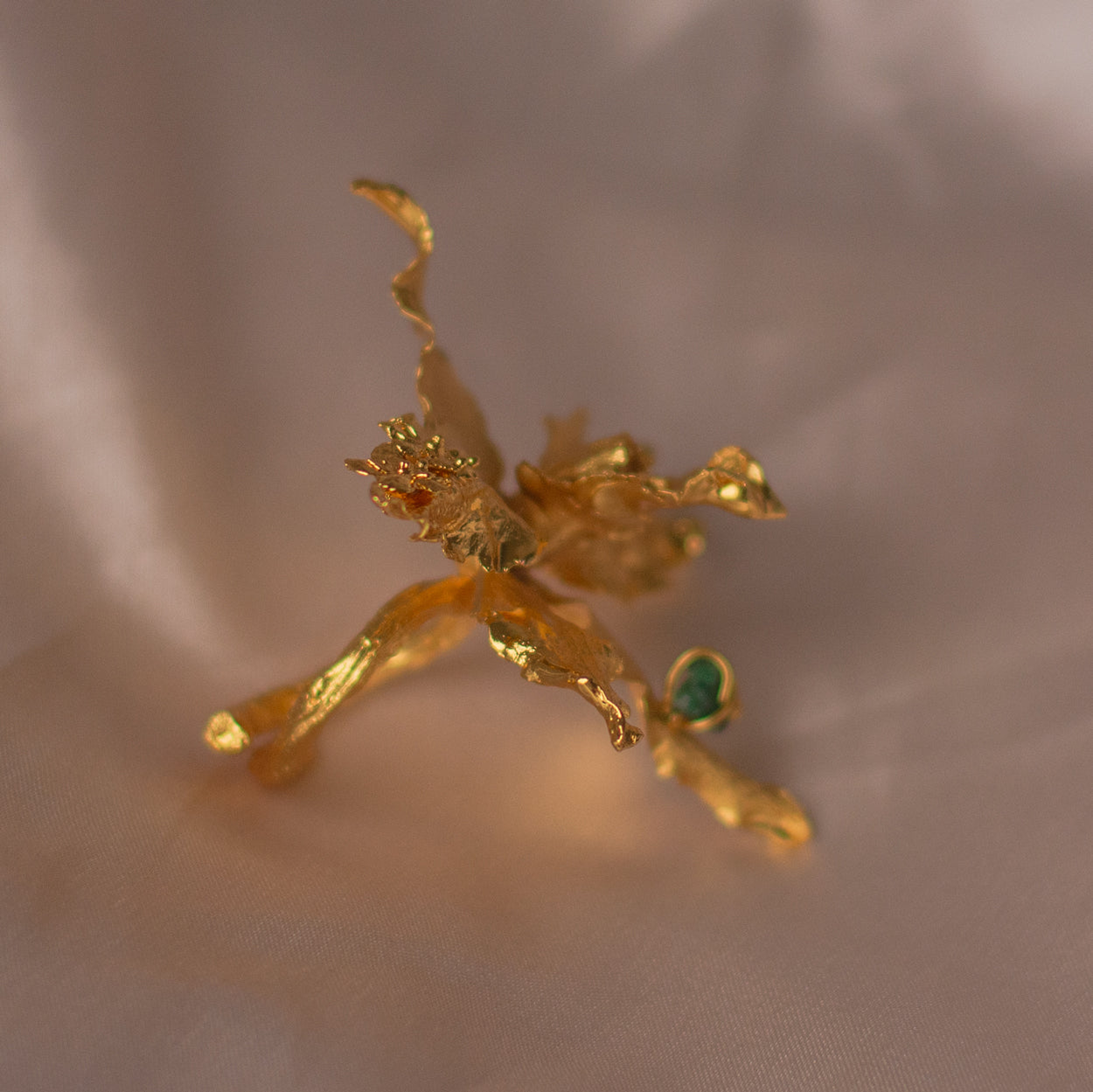 Close-up of Crispum Orchid Emerald Ring, highlighting the golden finish and sparkling emeralds