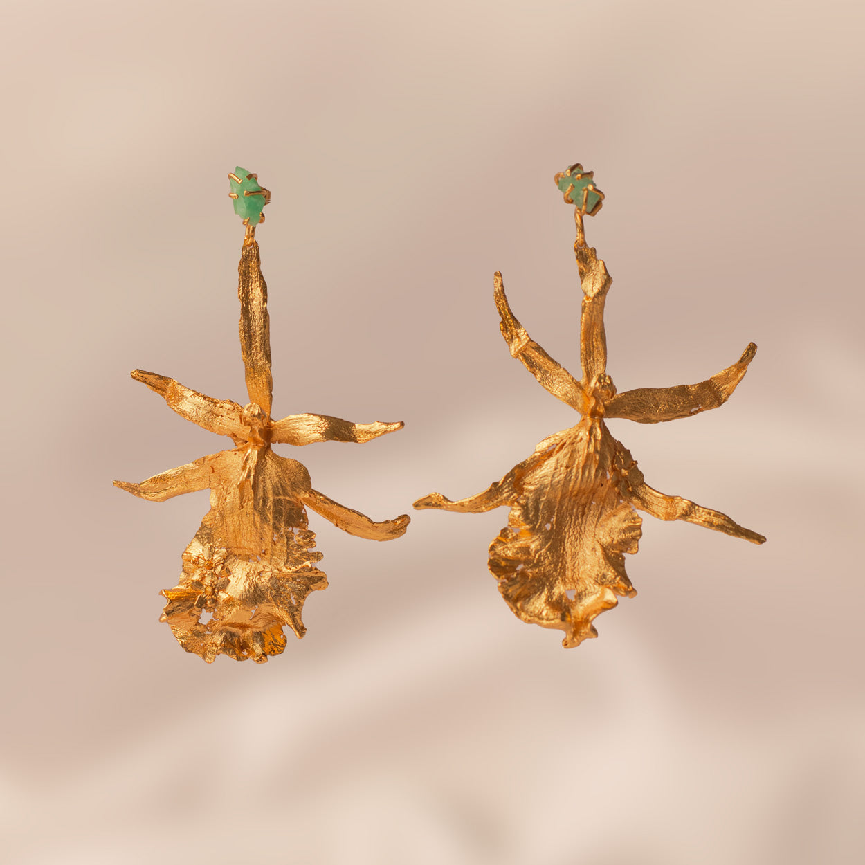 Brassia Orchid Earrings with pine leaves, elderflowers, and raw emeralds, plated with 24k gold.
