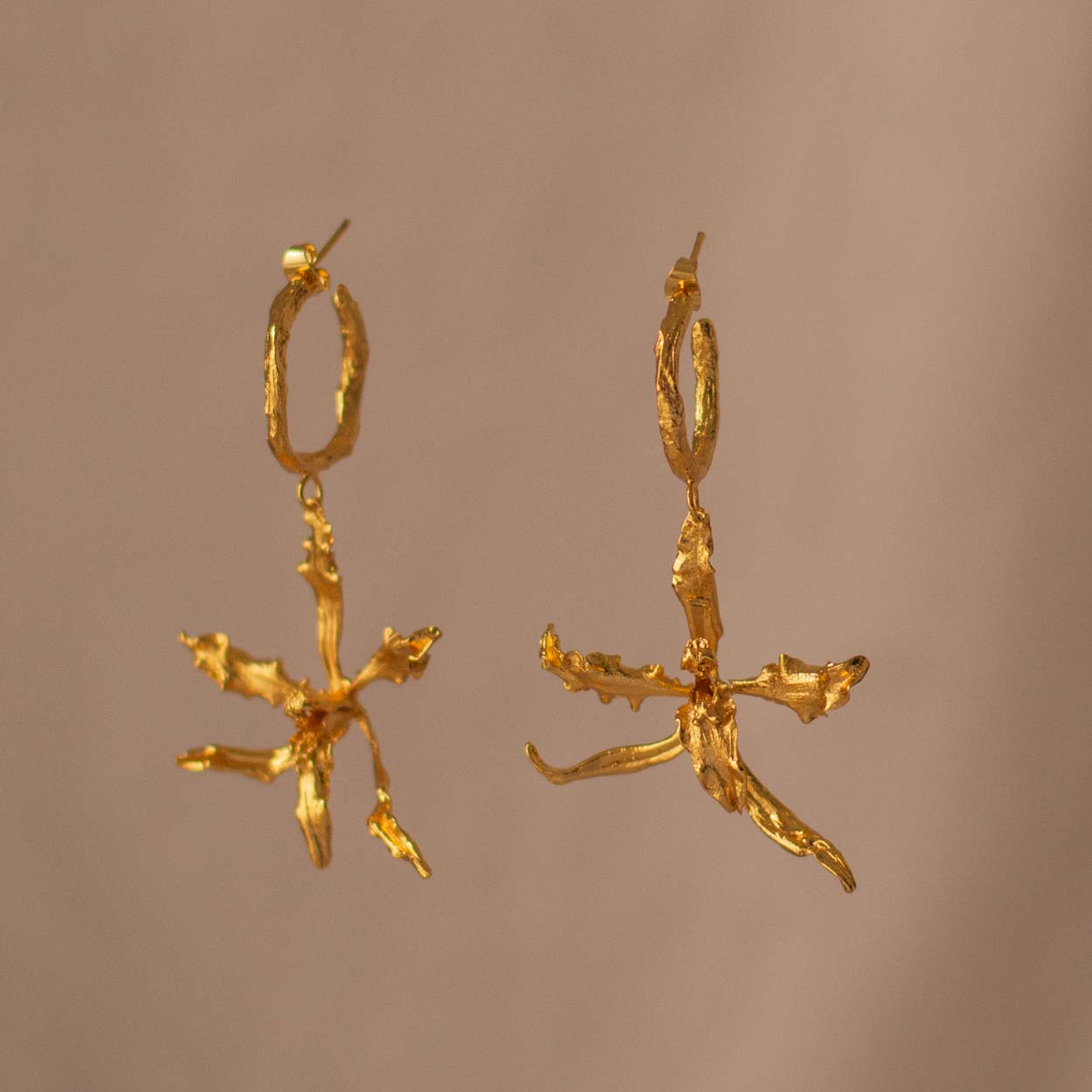 Elegant hoop earrings with Cyrtochilum Revolutum orchids, gold-plated in 24k, showcasing artisanal craftsmanship and unique floral design