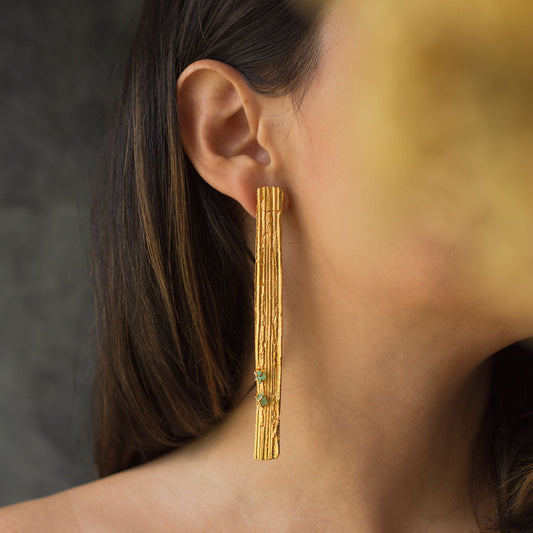 Large Palm Bark Emerald Earrings, handcrafted in bronze with 24k gold plating and adorned with Colombian emeralds, showcasing a blend of natural rusticity and luxury