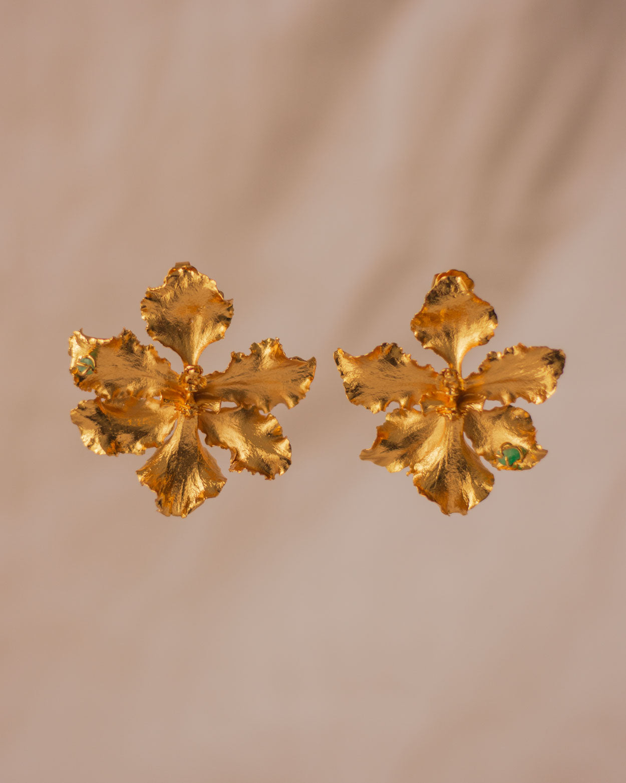 Close-up of Exotic Odontoglossum Orchid Earrings, featuring preserved flowers plated in 24k gold with emerald accents.