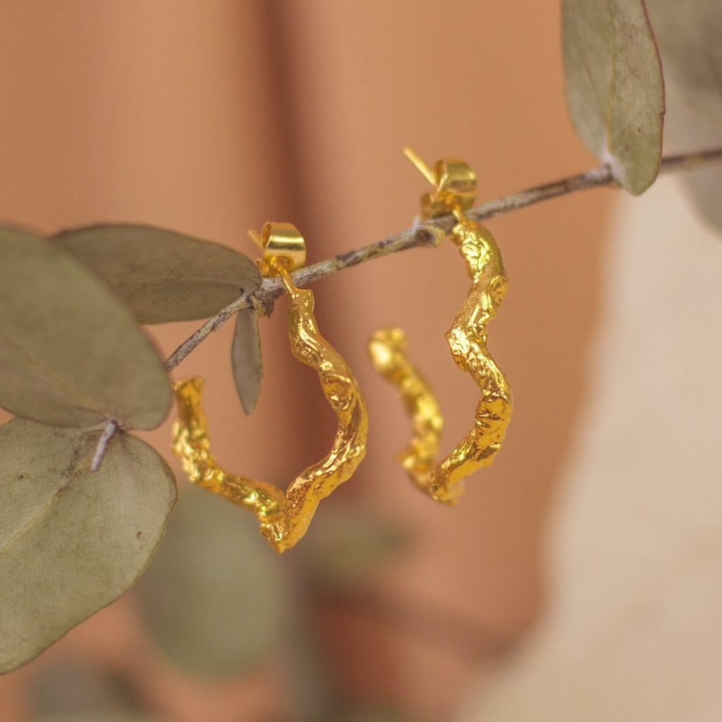 Aretes Aro Candonga Ramita Palma Pequeños en bronce bañado en oro de 24k, resaltando la textura natural de las ramitas de palma de coco inmortalizadas