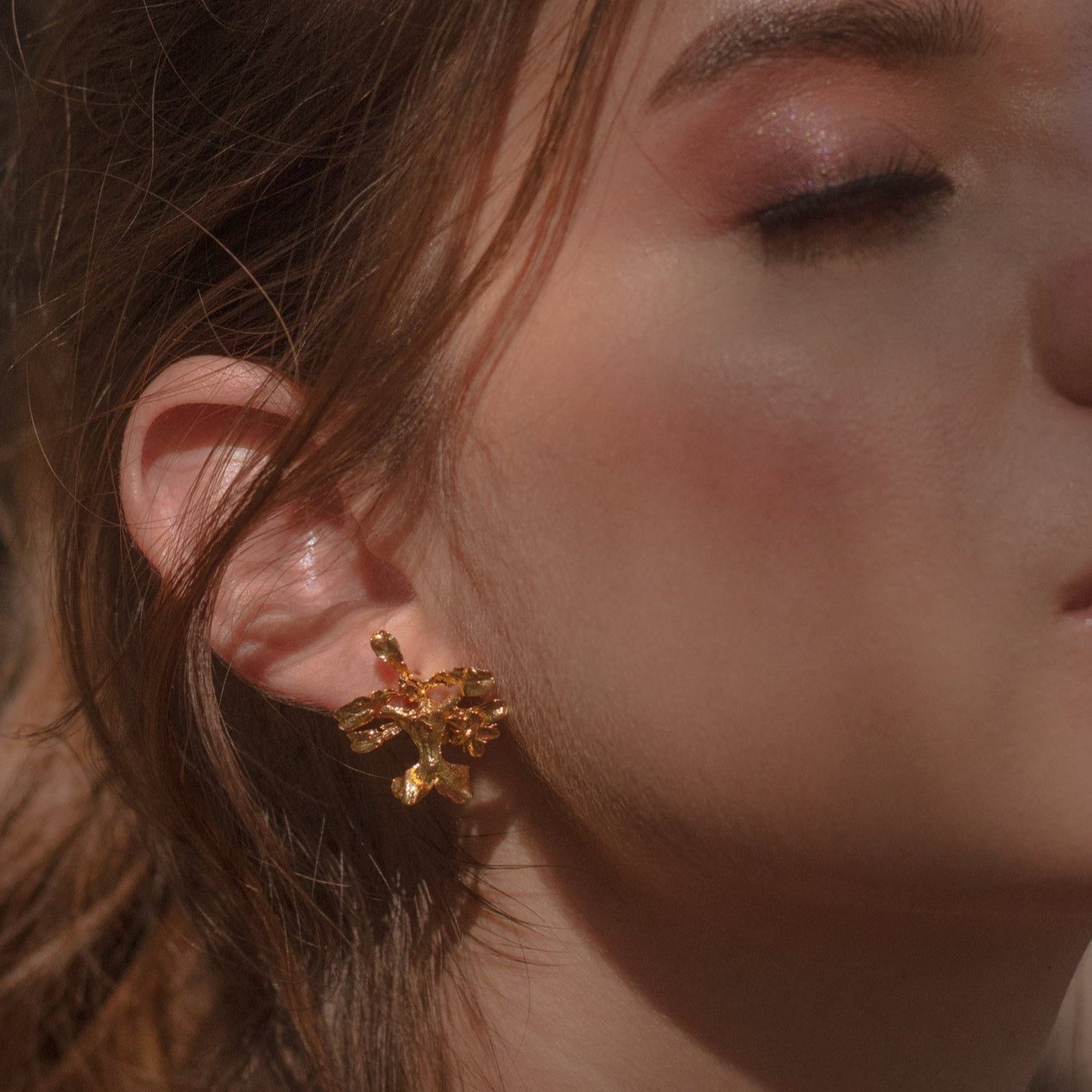 Aretes Topo Orquídea Oncidium en bronce bañado en oro de 24k, mostrando la delicada belleza de la orquídea natural preservada en metal precioso.