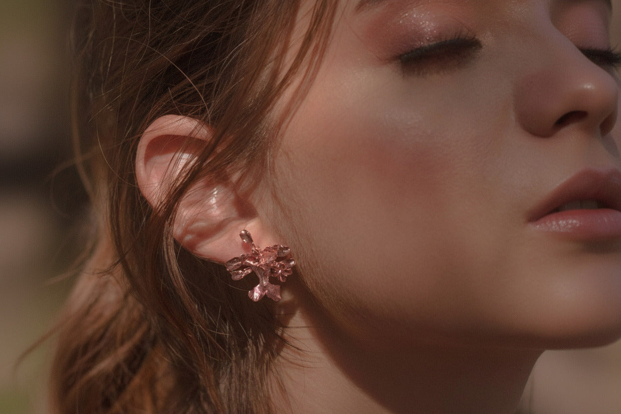 Aretes Topo Orquídea Oncidium en bronce bañado en oro de 24k, mostrando la delicada belleza de la orquídea natural preservada en metal precioso.