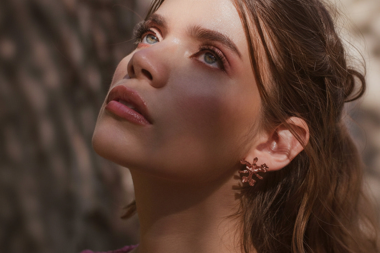 Aretes Topo Orquídea Oncidium en bronce bañado en oro de 24k, mostrando la delicada belleza de la orquídea natural preservada en metal precioso.