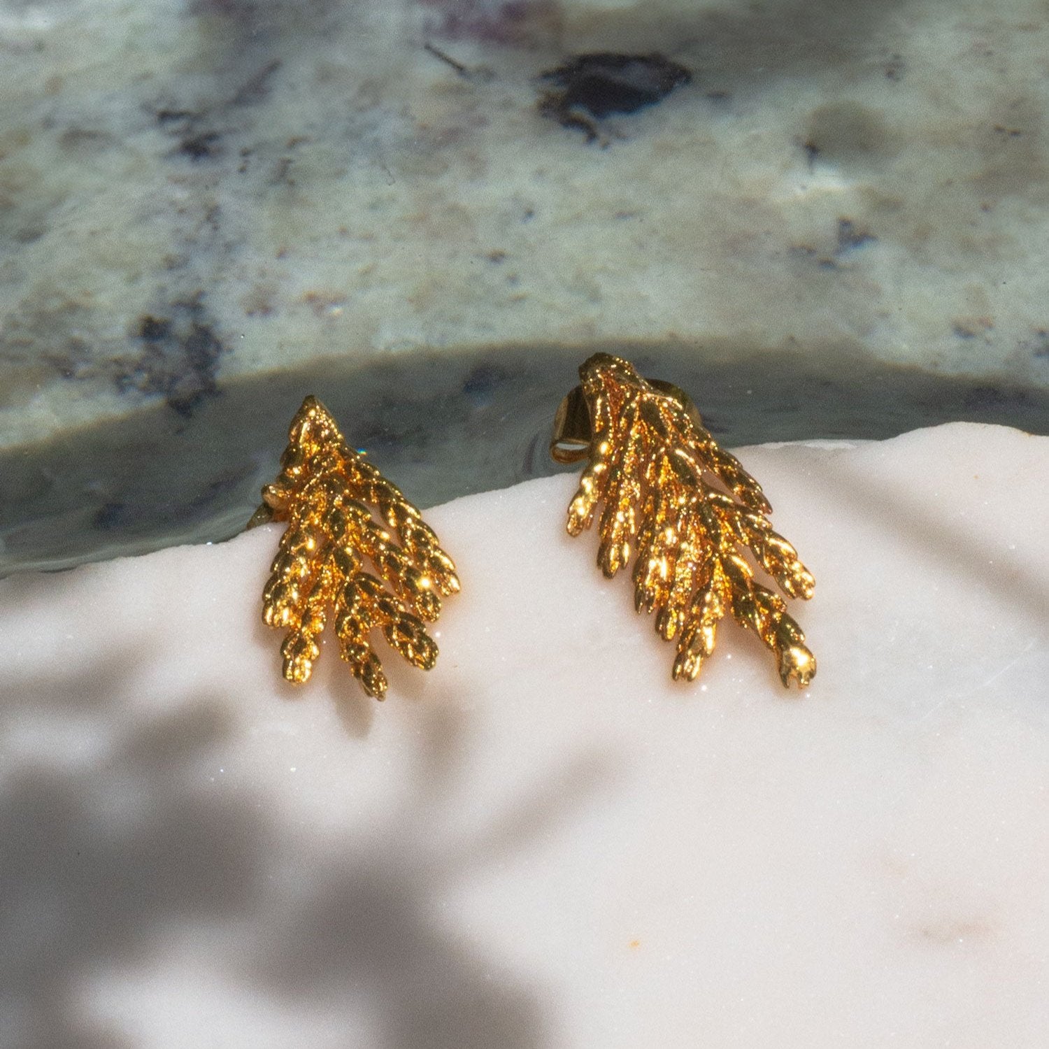 Close-up of Pine Leaf Stud Earrings, highlighting the preserved leaf texture and 24k gold plating.
