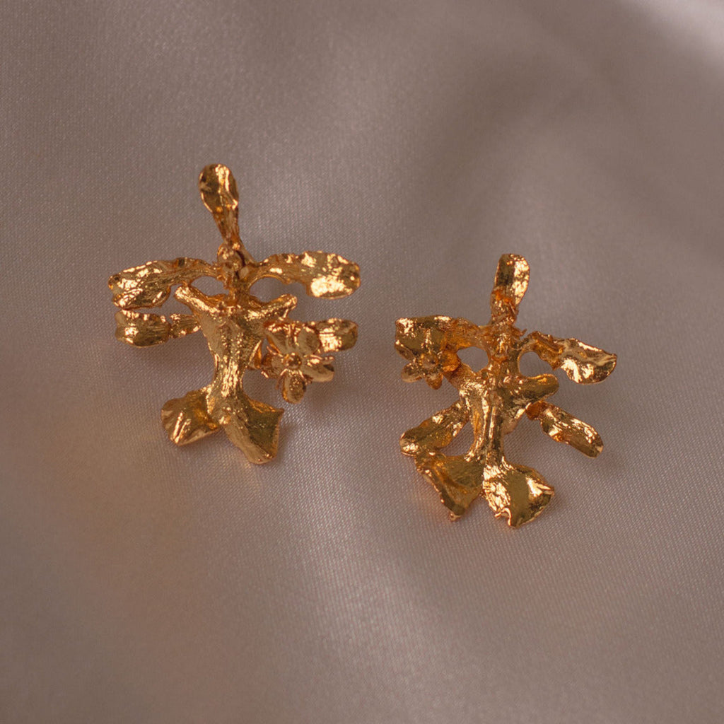 Aretes Topo Orquídea Oncidium en bronce bañado en oro de 24k, mostrando la delicada belleza de la orquídea natural preservada en metal precioso.