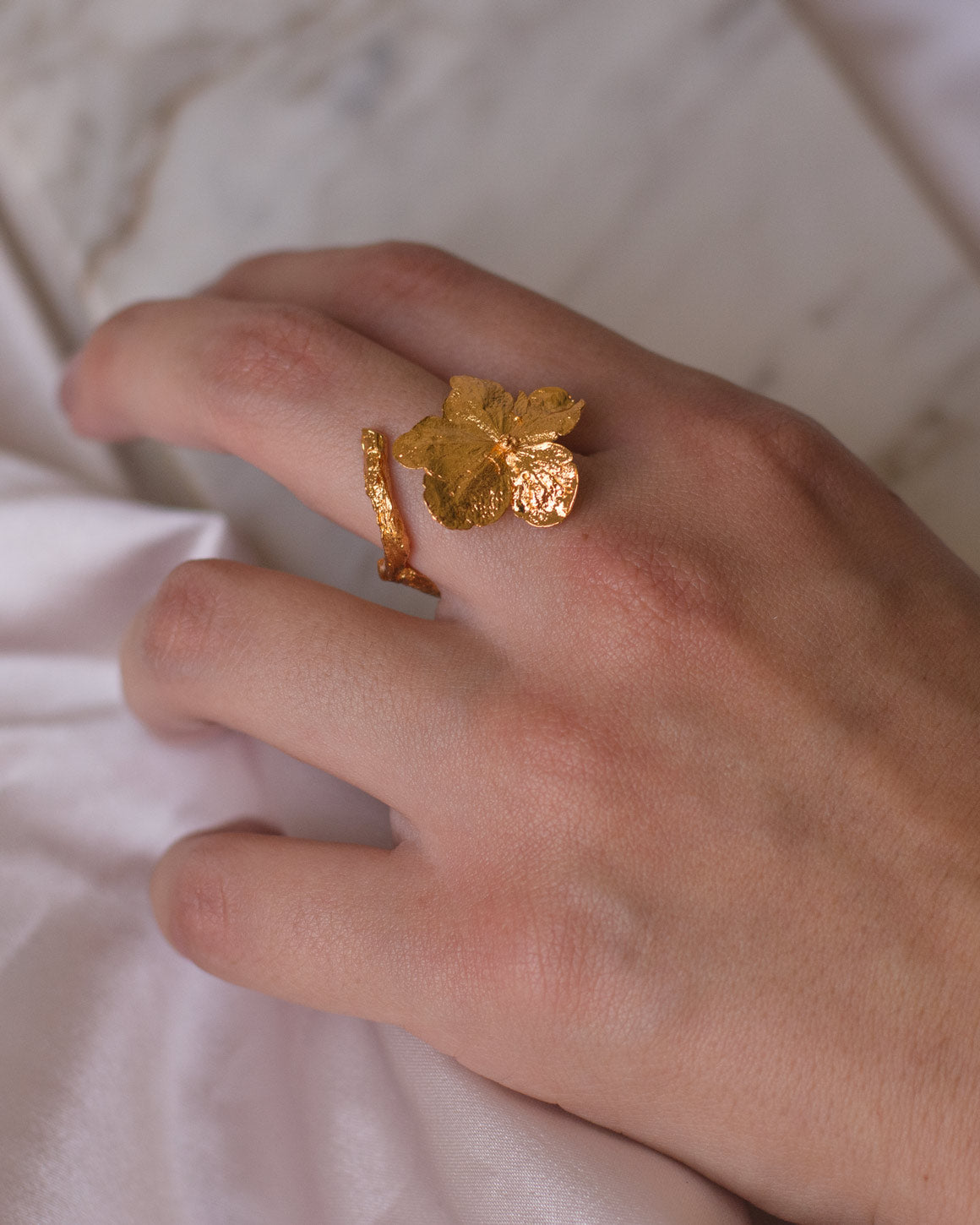 Anillo Hortensia Mini Natural en bronce bañado en oro de 24k, mostrando la exquisita belleza de una flor de hortensia inmortalizada en metal