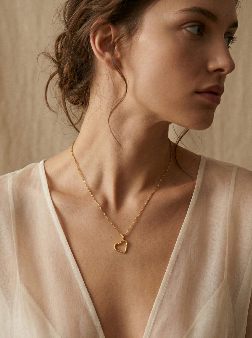 Mujer con collar de corazón de ramita natural bañado en oro 24k, joyería botánica artesanal colombiana Liz de la Cruz