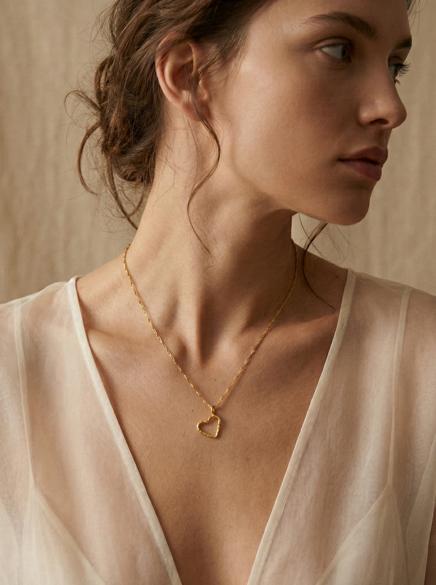 Mujer con collar de corazón de ramita natural bañado en oro 24k, joyería botánica artesanal colombiana Liz de la Cruz