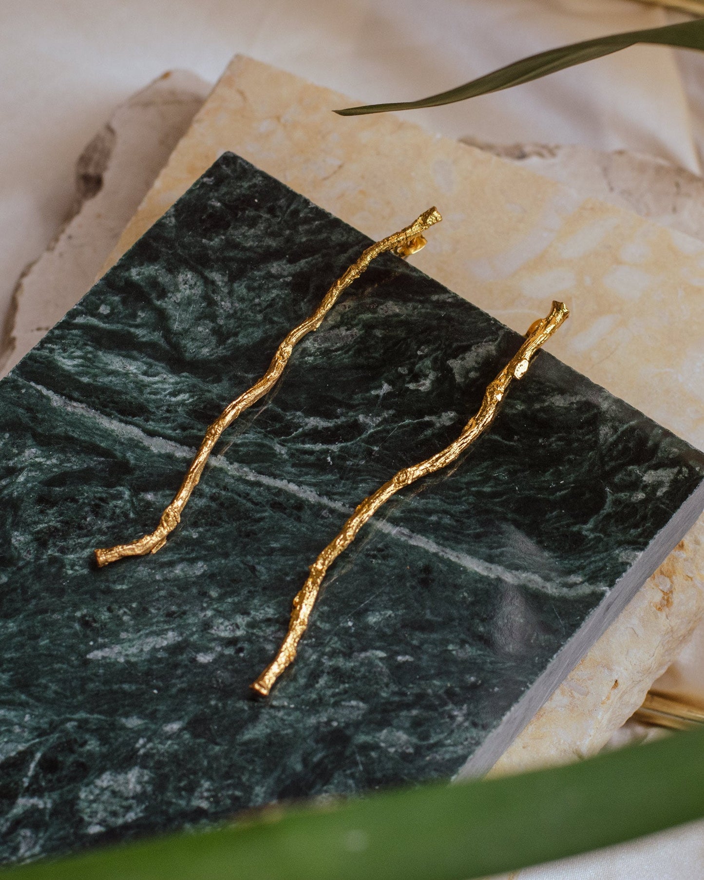 Close-up of Coconut Palm Earrings, highlighting the detailed twig structure and gold finish.
