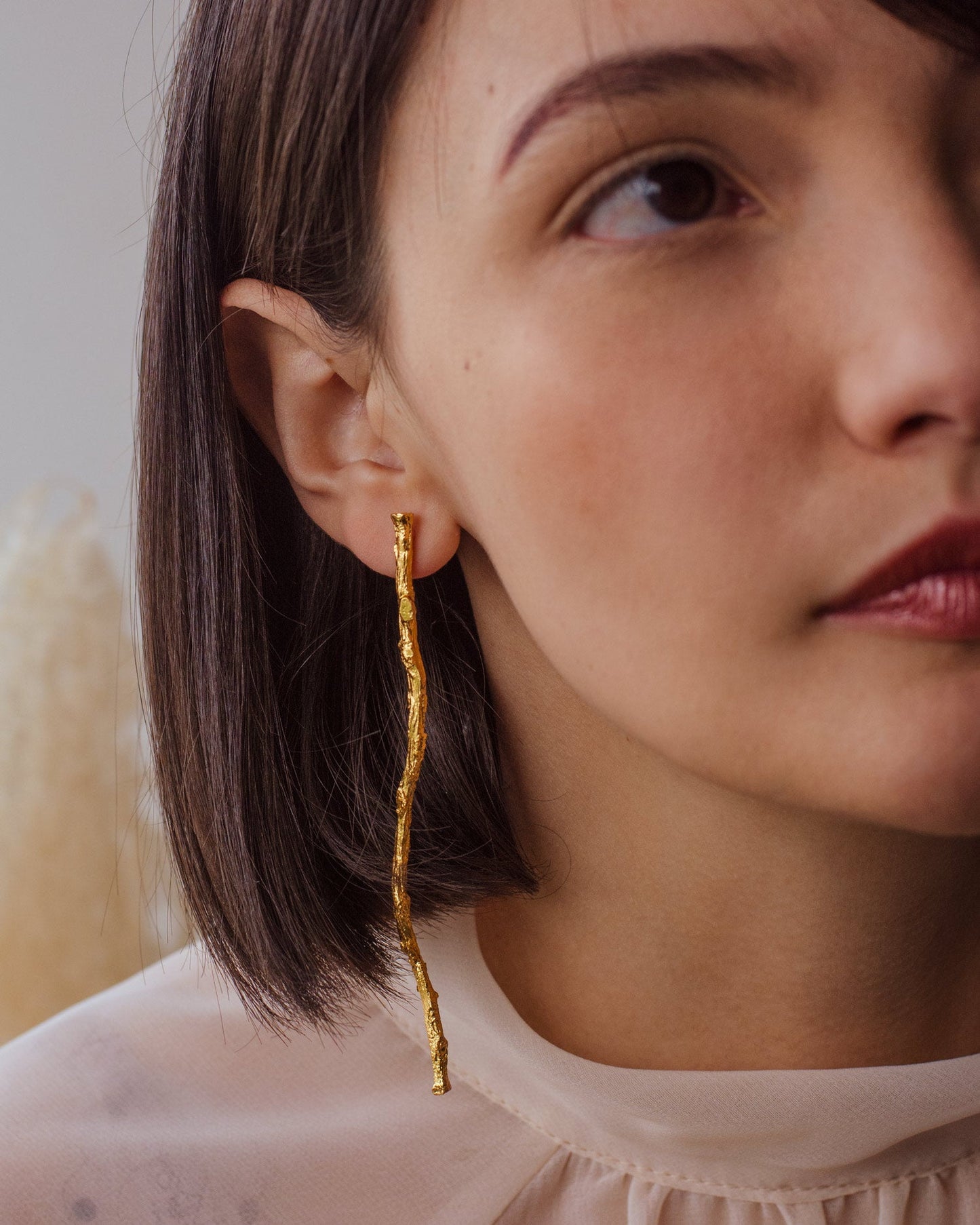 Model wearing Coconut Palm Twig Earrings, emphasizing their unique, nature-inspired design.
