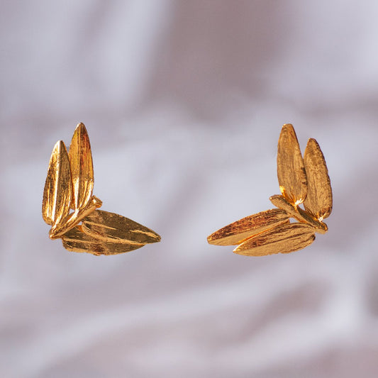 Close-up of Mini Romeron Pine Stud Earrings, showing the detailed bronze pine leaves with 24k gold plating